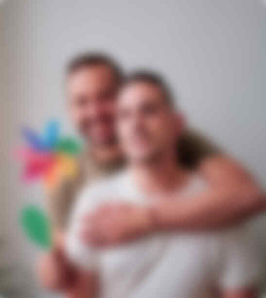 gay couple holding rainbow windmill